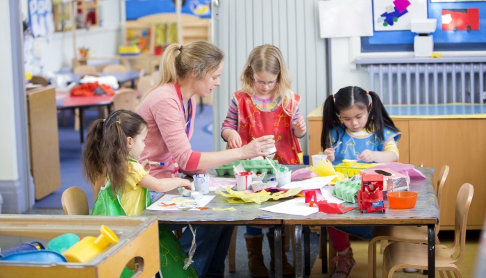 Teacher and nursery students doing arts and crafts in the classroom.