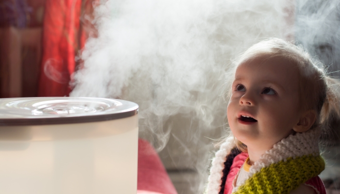 Little baby playing with humidifier.