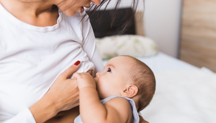 Beautiful mother breast feeding her cute little baby.