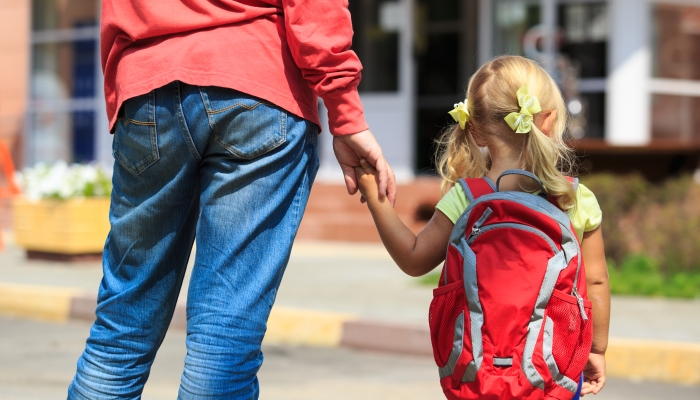 Father walking little daughter to school or daycare.