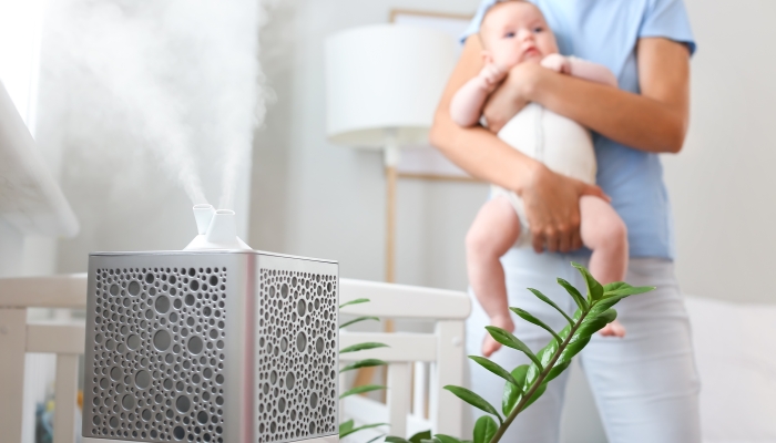 Modern humidifier in room with mother and her baby.