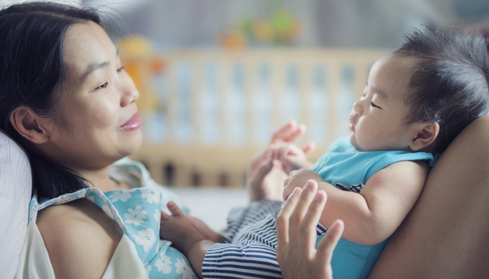 Mon and baby play togather in bed room.