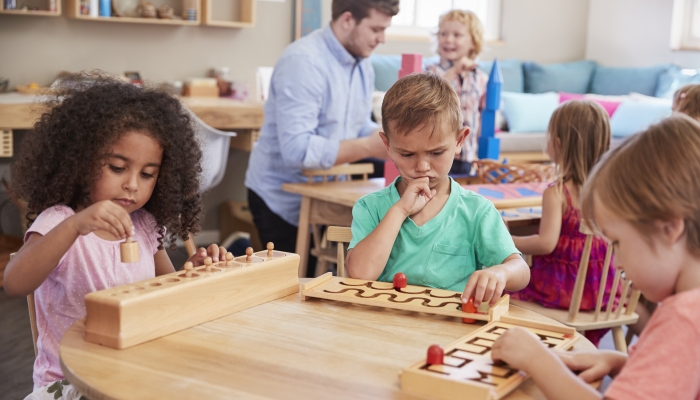 Teacher And Pupils In Montessori School.