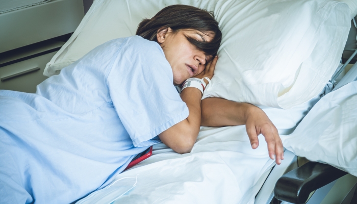 Young Caucasian woman resting in a hospital bed after giving birth.