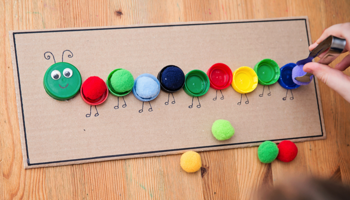 Matching colored pom poms in bottle caps.