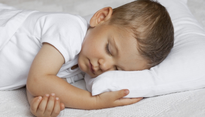 Cute child is sleeping in bed.