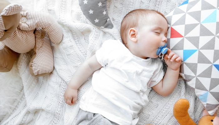 Cute sleeping baby boy with pacifier.