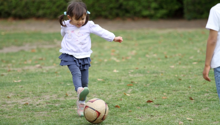 Japanese girl playing with soccer ball.