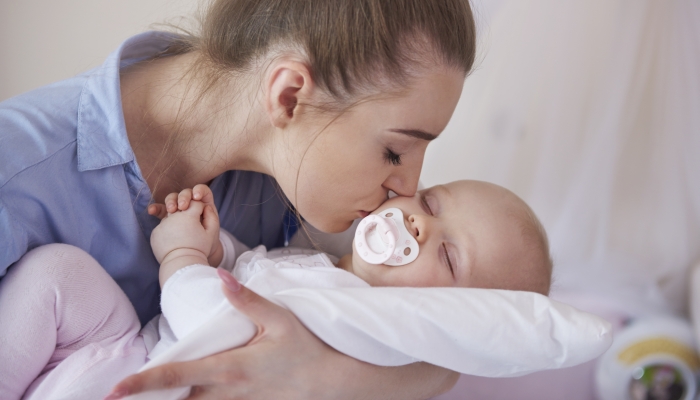 Mother with her baby daughter with pacifier.