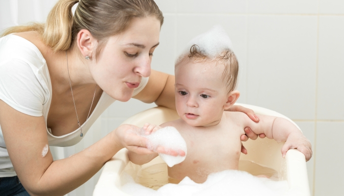 Portrait of young mother playing with her toddler.