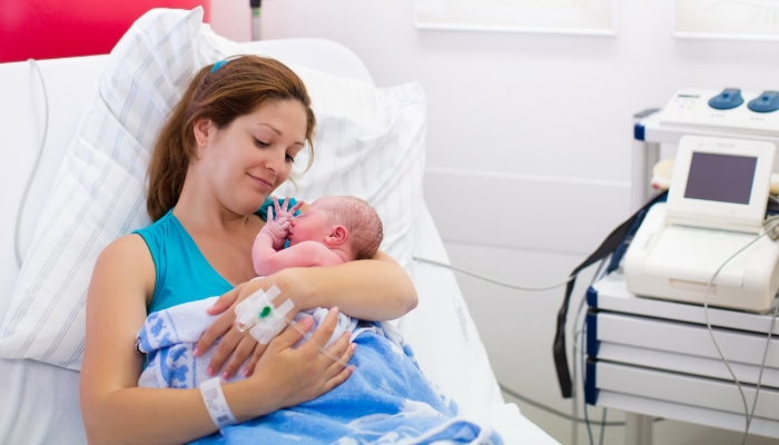 Young mother giving birth to a baby.