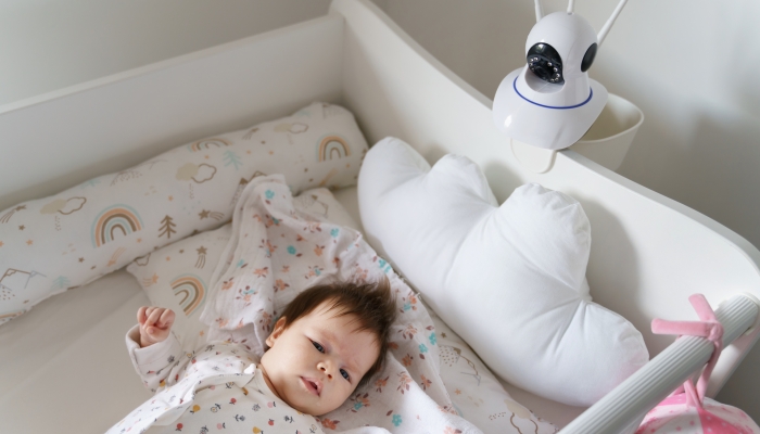 A home surveillance camera looks at the crib with a sleeping newborn baby.