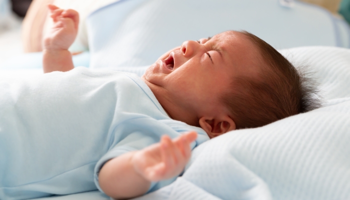 Asian baby newborn crying from diarrhea colic symptoms.