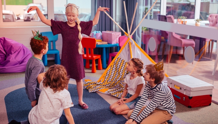 Beautiful child raising arms while playing guessing game.