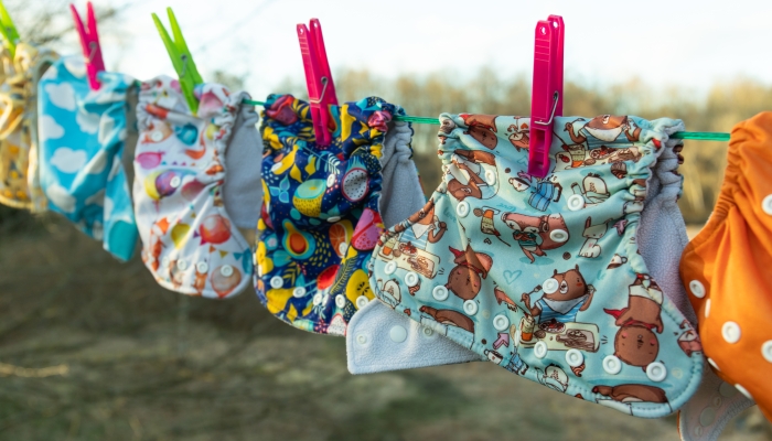 Cloth diapers dry in the sun on a full clothesline.