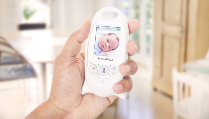 Father monitoring sleeping baby through baby monitor.