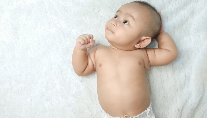 Funny Indonesian little baby wearing a diaper moving his head side to side.