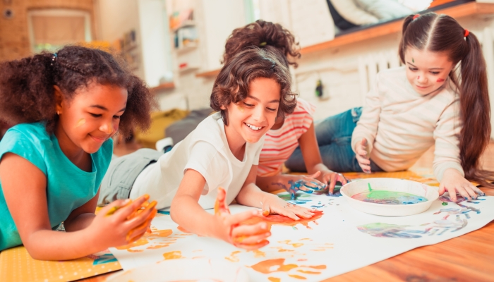 Kids enjoying painting with their fingers during the class.