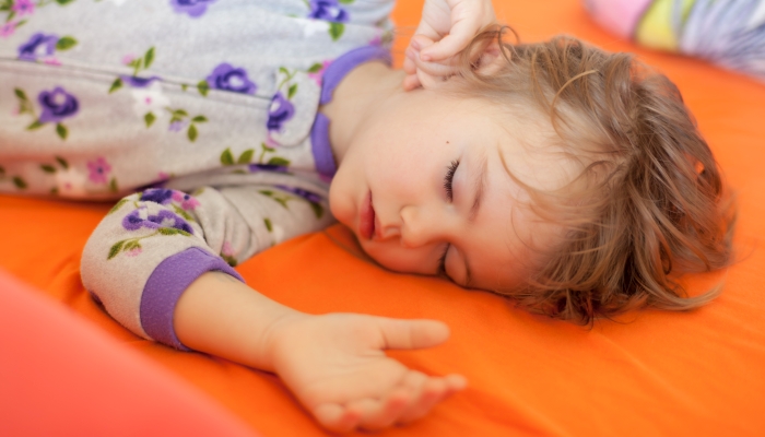 Little girl sleeping on the big bed.