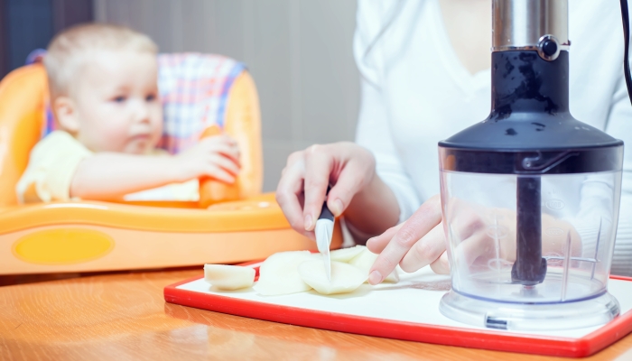 Mother cooking in blender, preparation of baby food.