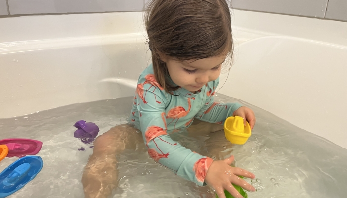 Girl playing toys while bathing.