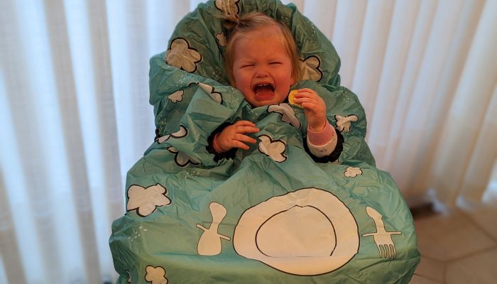 Baby crying while wearing Grabease bib.