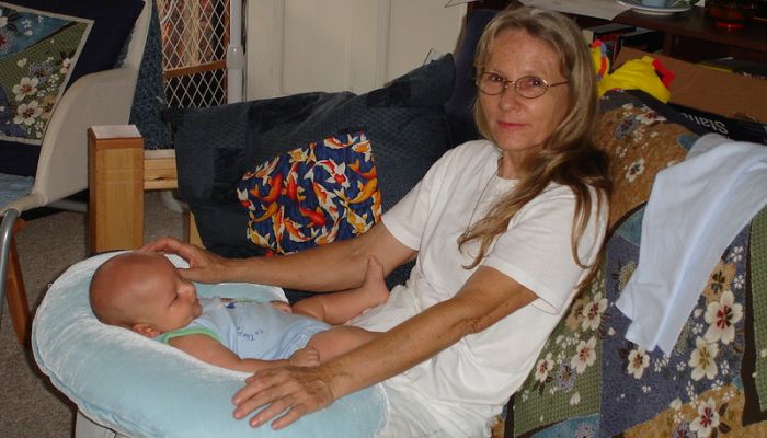 Baby and grandmother sitting with boppy pillow.