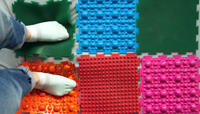 Feet standing on sensory mats.