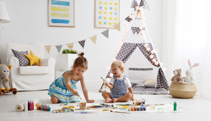 A happy funny children painting in a playroom.