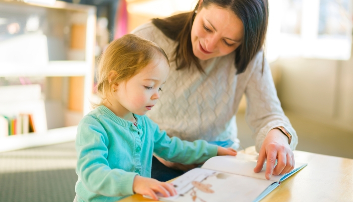 A mother and child looking picture books together at the library.