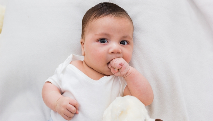 Adorable baby sucking his hand.