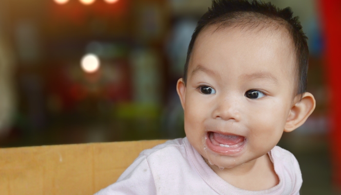 Asian baby girl spitting up.