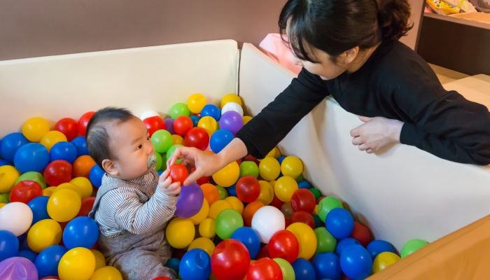 Asian baby playing in colorful ball pool (ball pit).