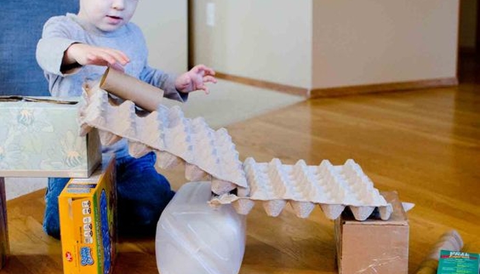 Child using recyclables to build.