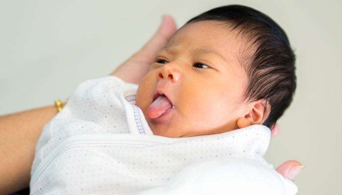 Cute girl baby sticking her tongue out because she's hungry.