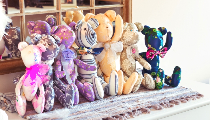 Many textile tilda teddy bear toys in workshop.