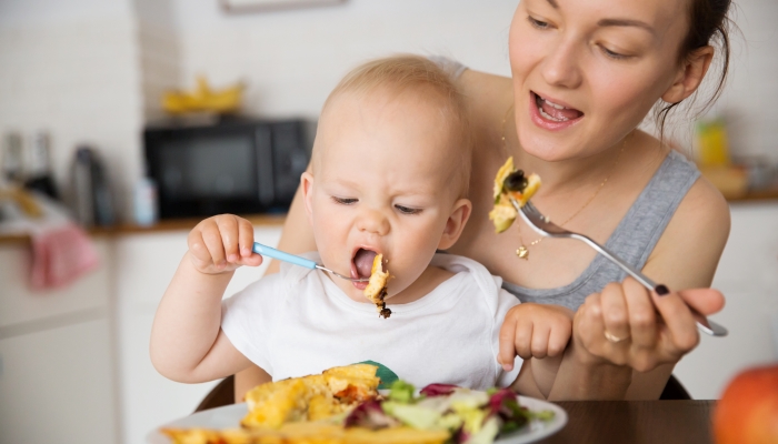 Mother and child eating together.