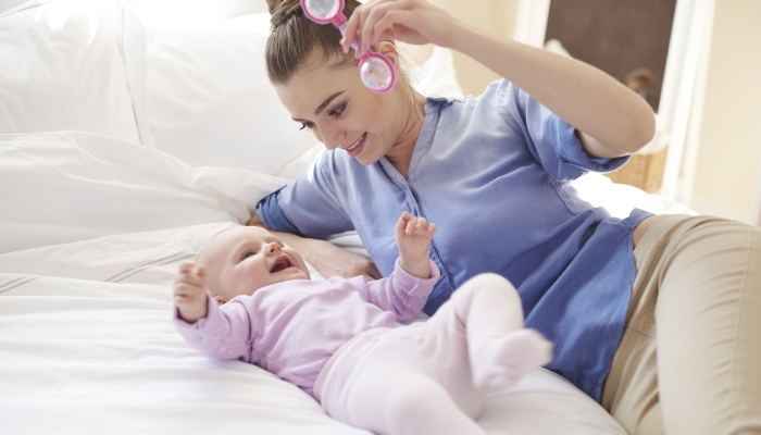 Mother using rattle to play with her baby.