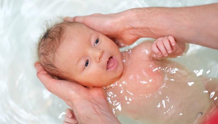 Newborn baby swimming in bath.
