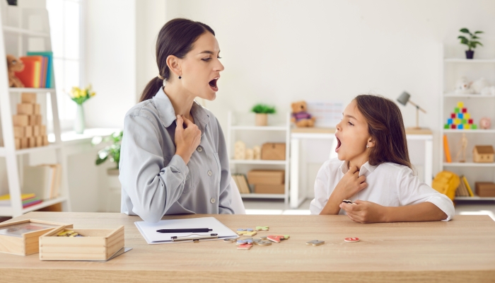 Speech-language pathologist working on child's pronunciation problems.