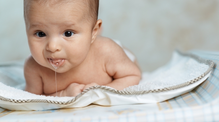 little beautiful baby drools lying on his stomach.