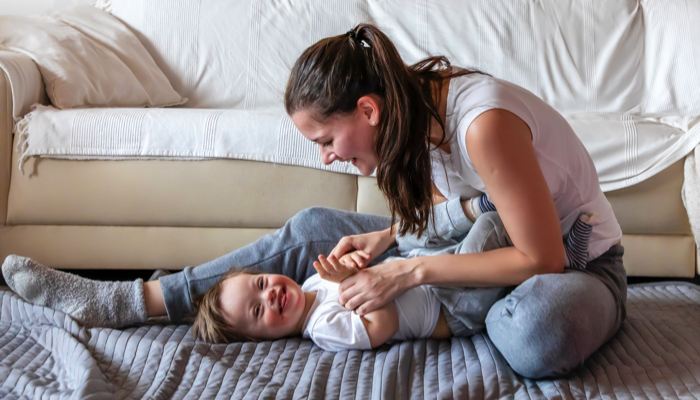 Mother and baby playing on the floor.