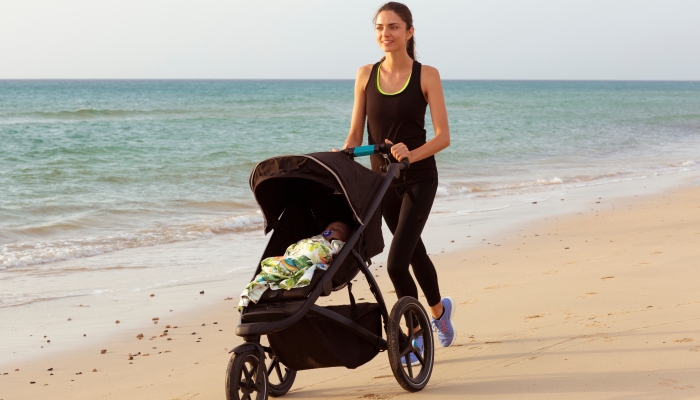 Beautiful mom and son doing a morning jogging on the beach.