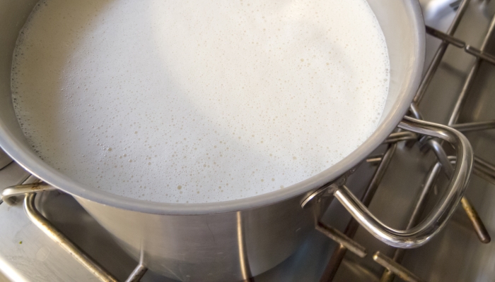 Industrial pot boiling fresh milk for consumption.