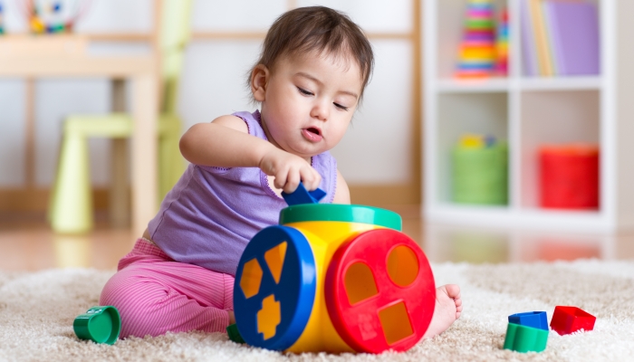 Kid girl plays with educational toy indoor.