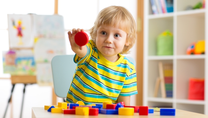 Little boy learning shapes, early education and daycare concept.