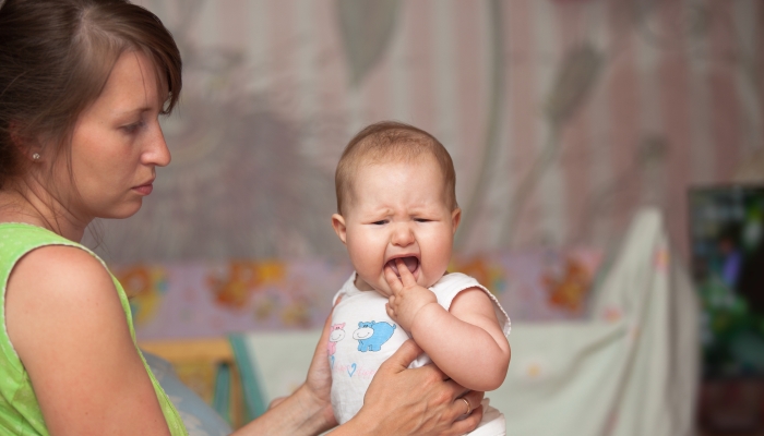 Mother with a crying baby due to teething.