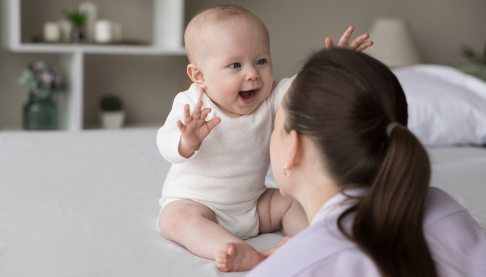 New mother talking to charming infant child.