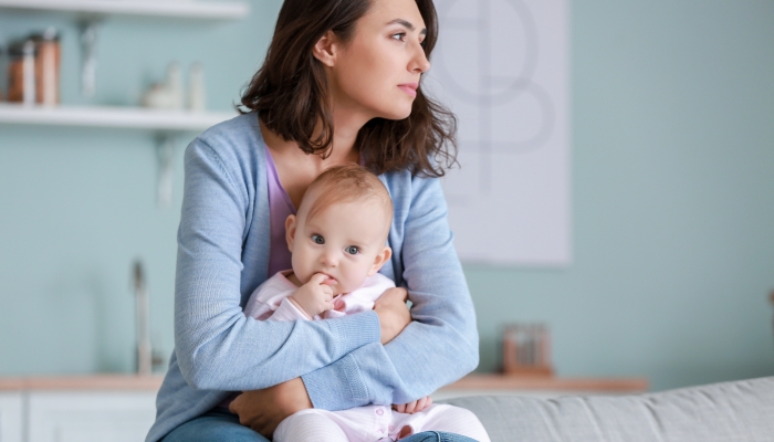 Young woman suffering from postnatal depression at home.