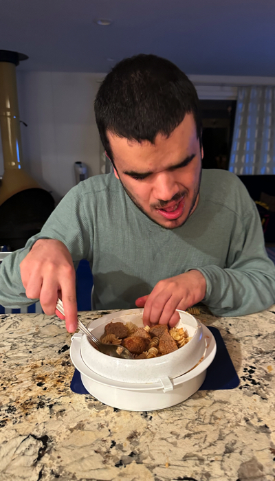 Michael eating with a plate guard.